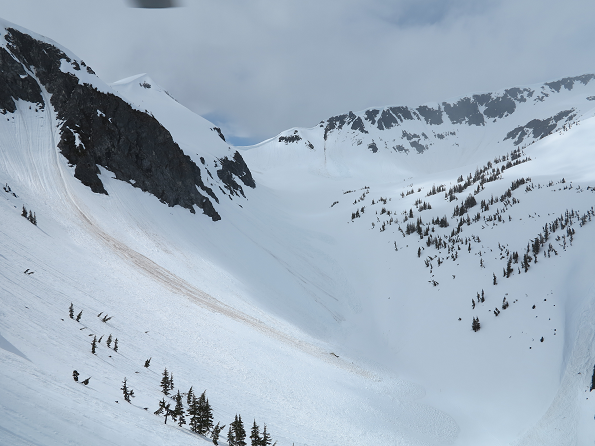 Une vue aérienne du site de l'écrasement sur le flanc de la montagne : la queue de l'hélicoptère figure comme une petite ligne sombre sur la neige de la vallée de montagne