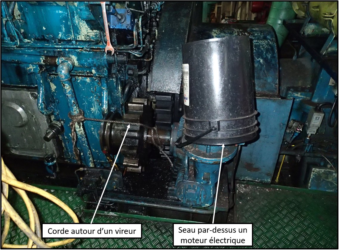 Seau protégeant le vireur du moteur principal contre une conduite qui fuyait, et corde autour du vireur (Source : BST)