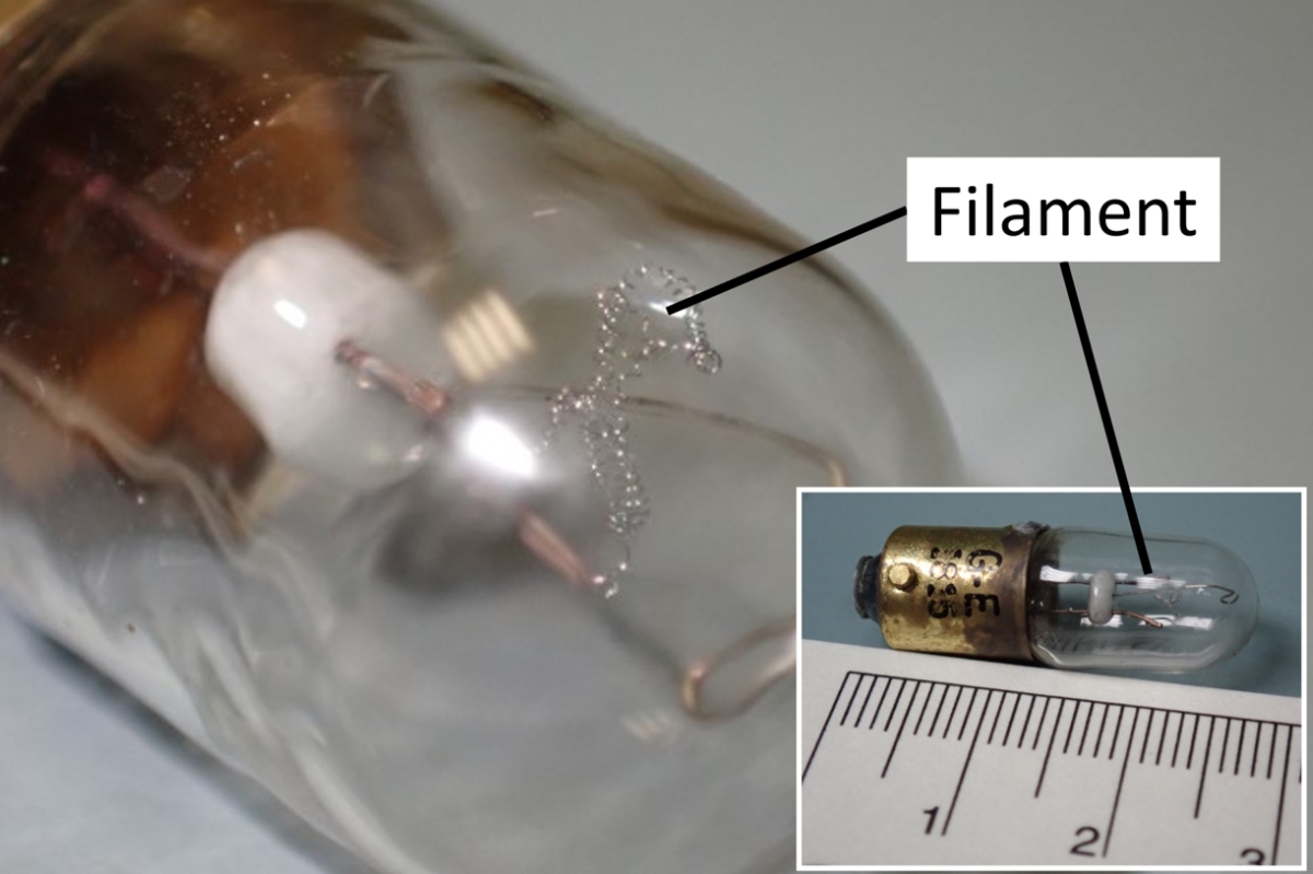 Figure 4. Vue agrandie du filament de l’ampoule retirée de l’avertisseur de décrochage de l’aéronef à l’étude, avec une vue complète de l’ampoule en médaillon (référence d’échelle en cm) (Source des images : BST)