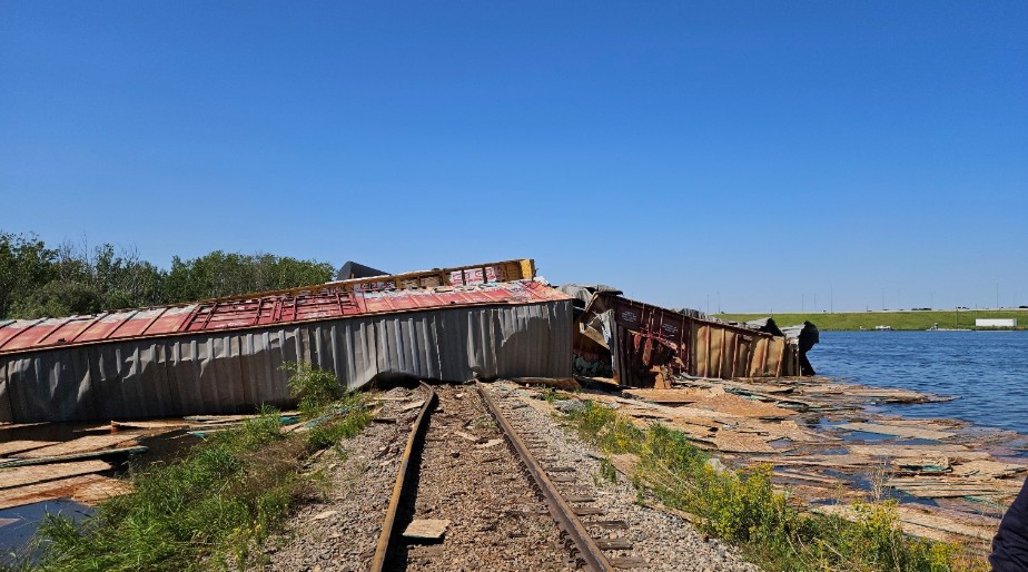 Plusieurs des wagons ayant déraillé se sont immobilisés en travers de l'emprise de chemin de fer et s'étendaient jusque dans un plan d'eau adjacent. le 13 juillet 2026, dont certains sont tombés dans un plan d'eau situé à proximité de la voie ferrée (Source : Bureau de la sécurité des transports du Canada)